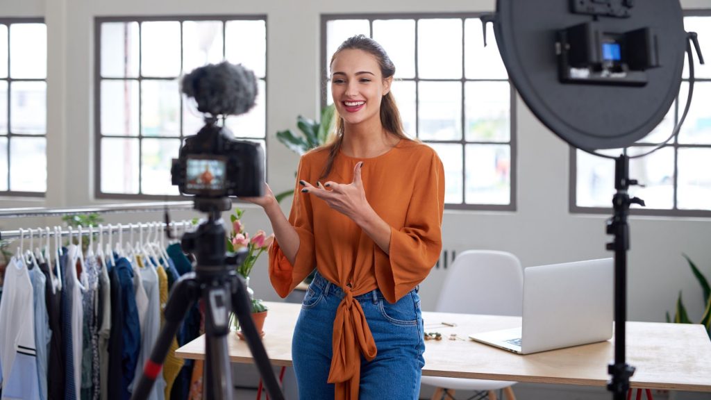 Chica delante de una cámara creando contenido para redes sociales