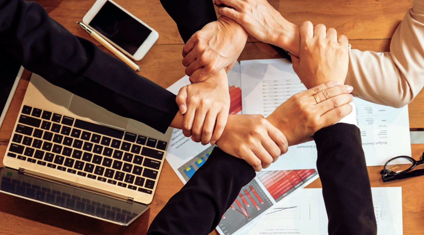 Varias manos cruzando simbolizando el compromiso en nuestra agencia de Marketing Digital