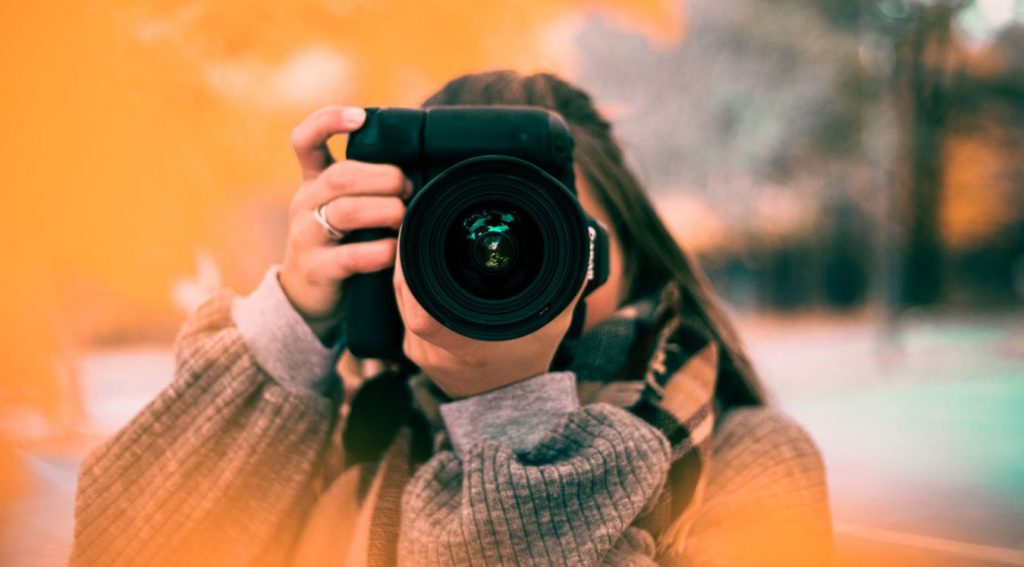 Chica con una cámara haciendo fotos para contenido de Redes Sociales