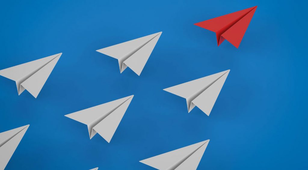 Imagen mostrando unos aviones de papel y uno de color rojo, representando la personalzación al gusto del cliente