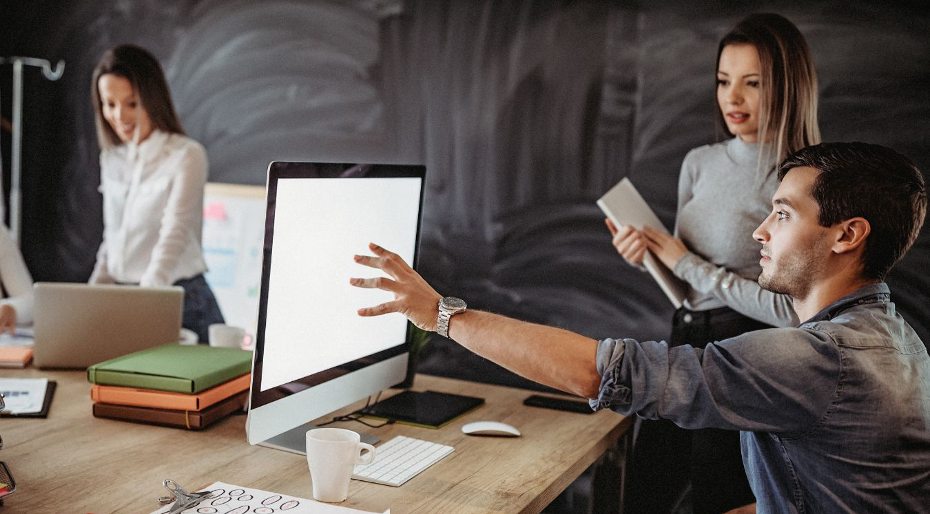 Personas en una agencia de marketing mostrando resultados a través de una pantalla